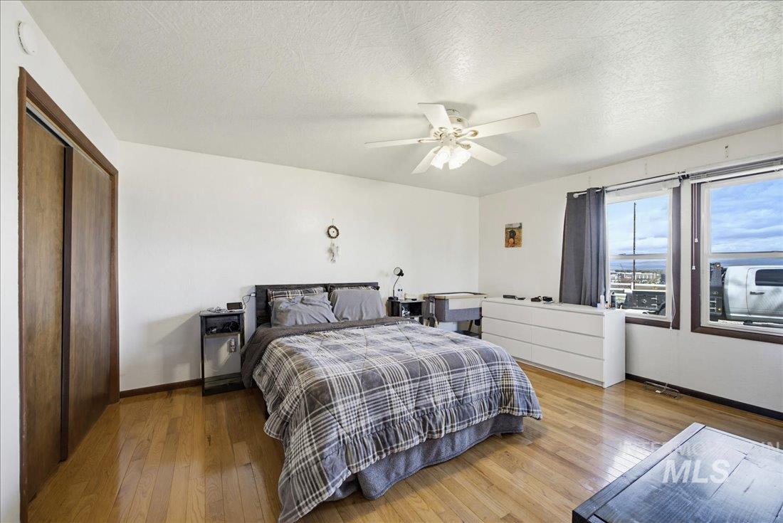 1901 South Ten Mile Road Meridian, ID 83642 - Photo 18 of 32 Spacious room featuring wood-finish flooring, a ceiling fan, and ample natural light from two large windows