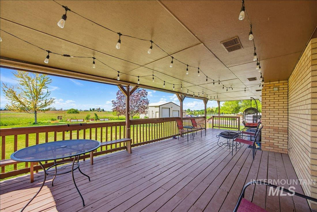 1901 South Ten Mile Road Meridian, ID 83642 - Photo 23 of 32 Expansive covered deck featuring wood-finish flooring, string lighting, and a perimeter railing