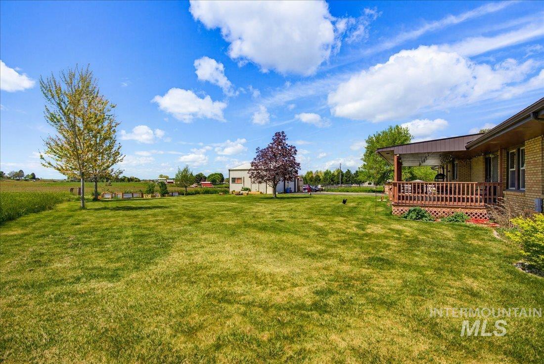1901 South Ten Mile Road Meridian, ID 83642 - Photo 29 of 32 Expansive green lawn with a covered porch featuring wooden railings and lattice accents