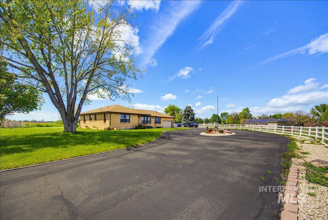 1901 South Ten Mile Road Meridian, ID 83642 - Photo 3 of 32 Expansive paved driveway leading to a brick-faced ranch-style residence