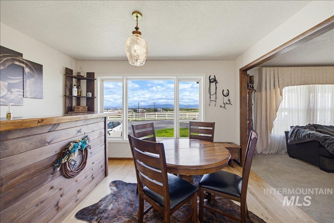 1901 South Ten Mile Road Meridian, ID 83642 - Photo 7 of 32 Dining area featuring light wood-finish flooring, a built-in wood-paneled bar with a solid wood countertop, and a corner shelving unit