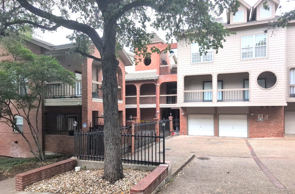3200 Duval Street, Unit 102 Austin, TX 78705 - Photo 1 of 20 a front view of a building with glass windows and a tree