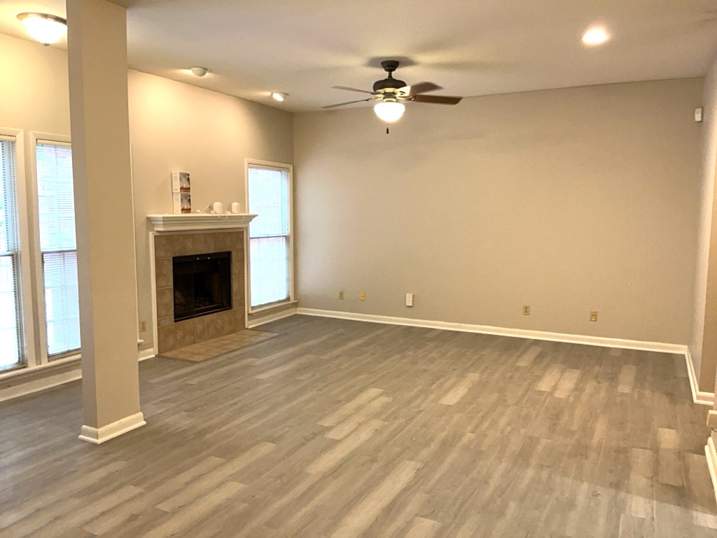 3200 Duval Street, Unit 102 Austin, TX 78705 - Photo 4 of 20 an empty room with wooden floor fireplace and windows