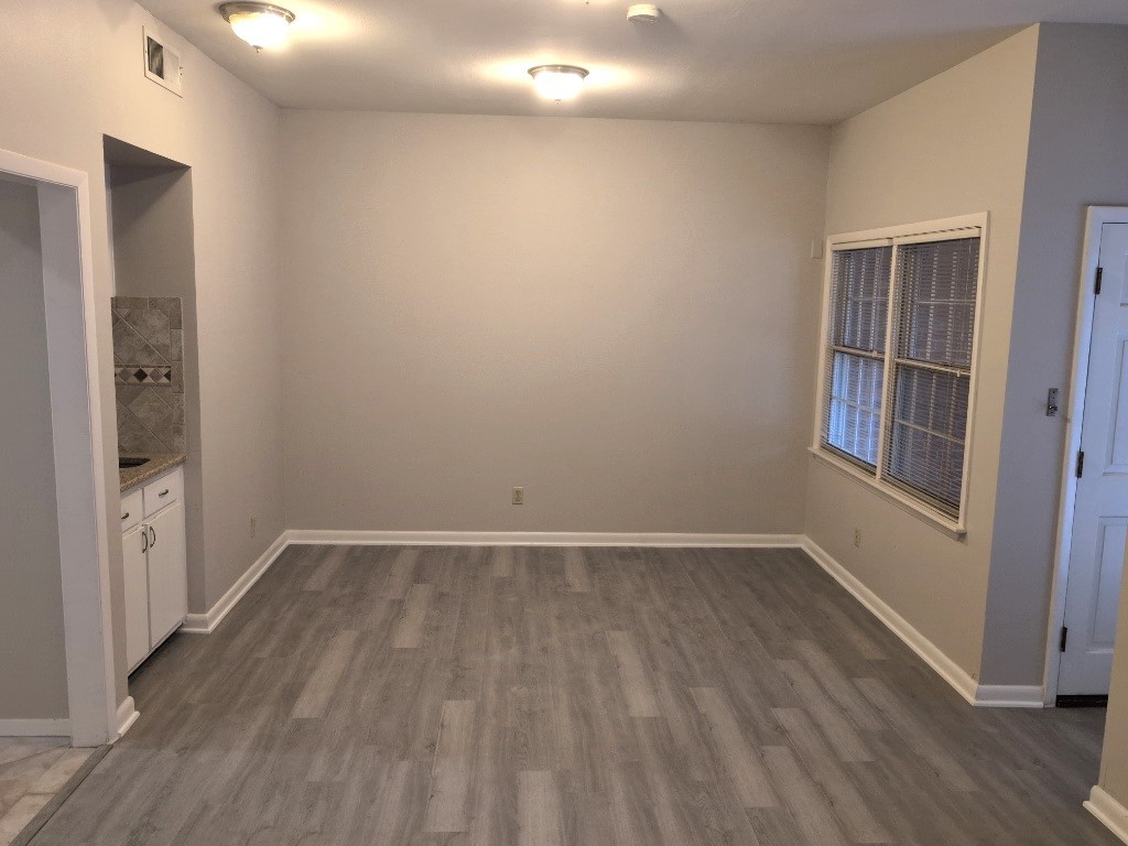 3200 Duval Street, Unit 102 Austin, TX 78705 - Photo 8 of 20 an empty room with wooden floor and windows