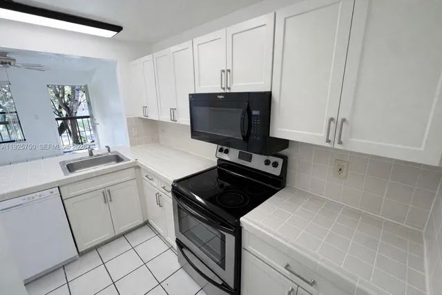 a kitchen with appliances a sink and cabinets