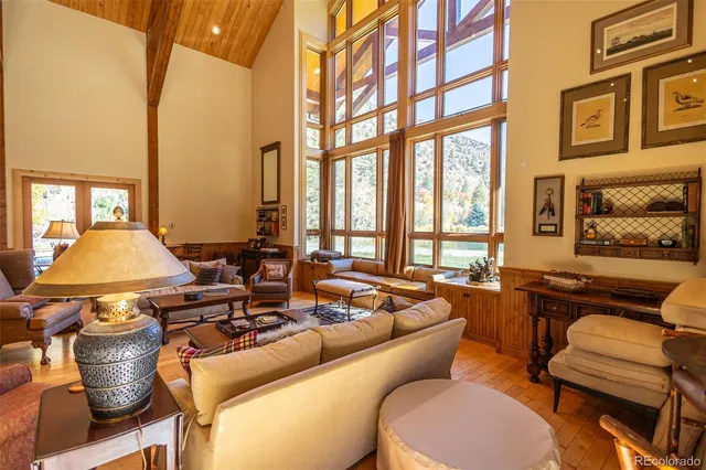 a living room with furniture fireplace and large windows