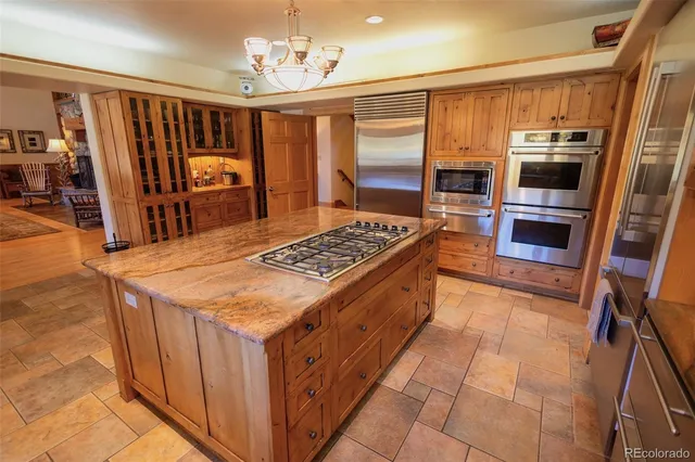 a kitchen with stainless steel appliances granite countertop a stove top oven a refrigerator a sink and dishwasher