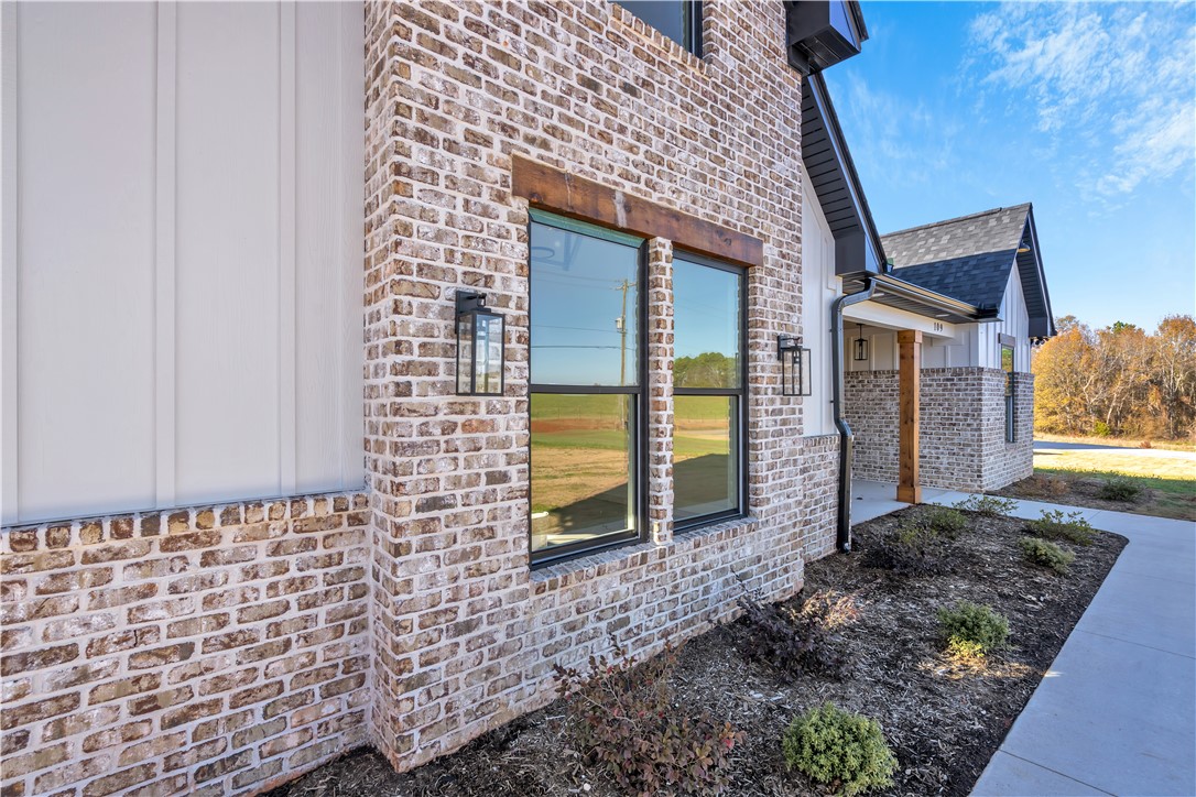 516 Lakeside Drive Anderson, SC 29621 - Photo 5 of 32 A striking facade with varied brick and vertical siding, punctuated by stylish windows and accent lighting.
