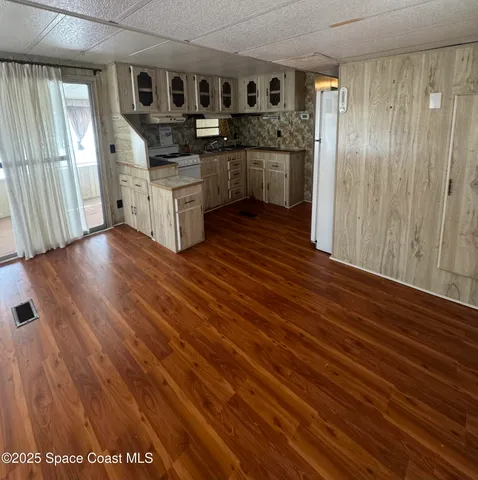 a kitchen with stainless steel appliances granite countertop a refrigerator a stove and a wooden floors