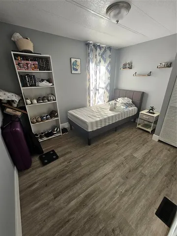 a bedroom with a bed and wooden floor