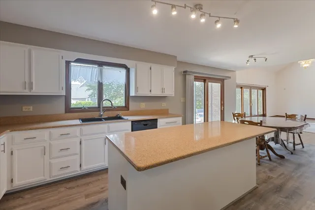 a kitchen with granite countertop a sink and white cabinets