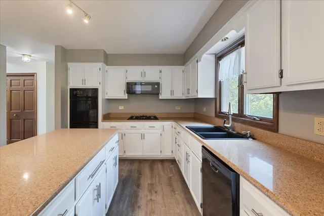 a kitchen with granite countertop a sink stove and refrigerator