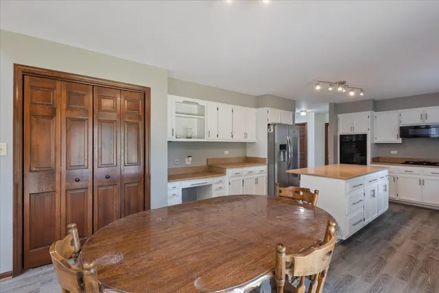 a large kitchen with a table and refrigerator
