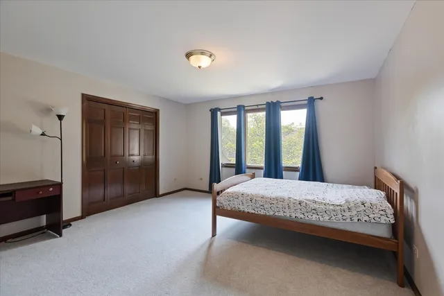 a bedroom with a bed and a dresser next to a window