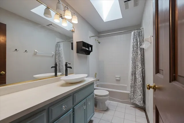 a bathroom with a granite countertop sink a toilet a mirror and shower