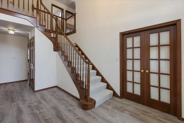 a view of staircase with wooden floor and white walls