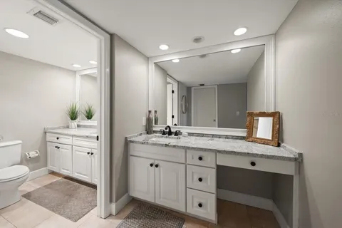 a spacious bathroom with a granite countertop sink mirror and toilet