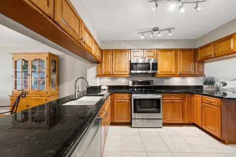 a kitchen with stainless steel appliances granite countertop a sink stove and cabinets