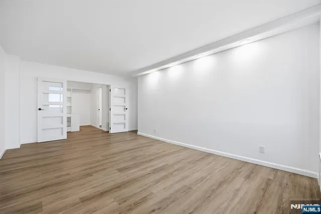 a view of empty room with wooden floor