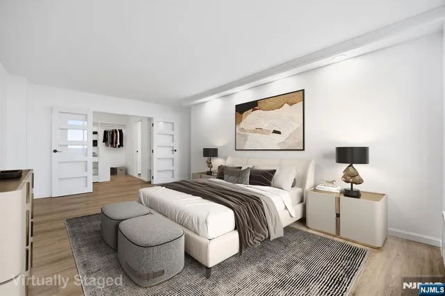 a spacious bedroom with a bed and a painting on the wall