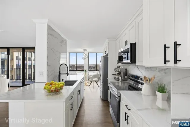 a kitchen with stainless steel appliances a sink a stove and cabinets