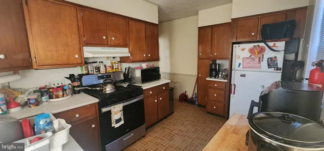 a kitchen with a stove refrigerator and sink
