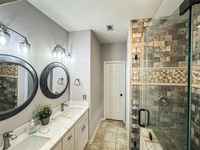 a bathroom with a granite countertop sink mirror vanity and toilet
