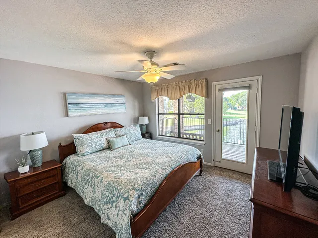 a bedroom with a bed flat screen tv and a large window