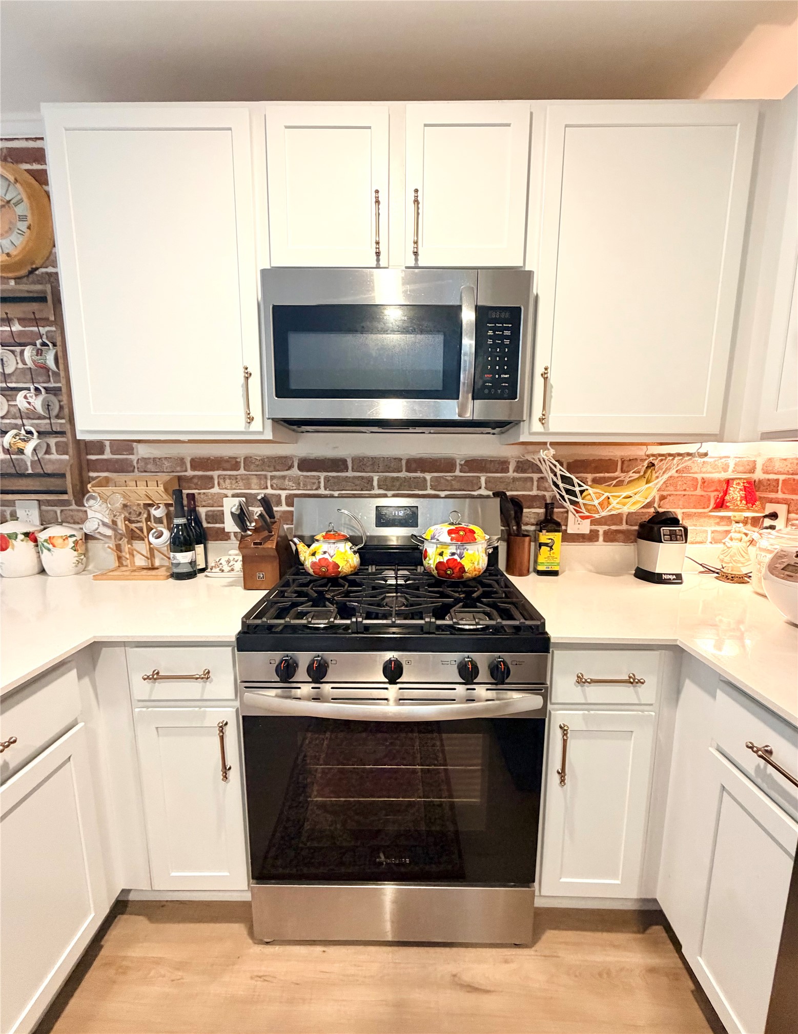 532 Flower Reed Court Magnolia, TX 77354 - Photo 16 of 43 This kitchen features modern white cabinets, a stainless steel gas stove, and microwave. The brick backsplash adds a rustic touch! The layout is efficient, making it ideal for cooking!