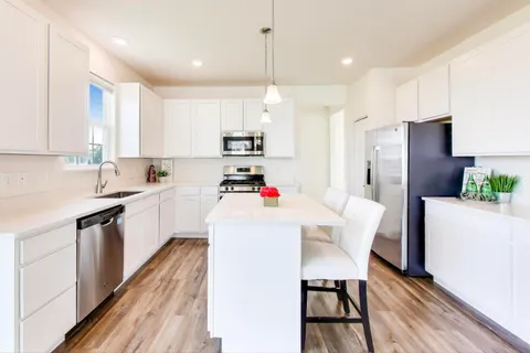 a kitchen with white cabinets and white appliances