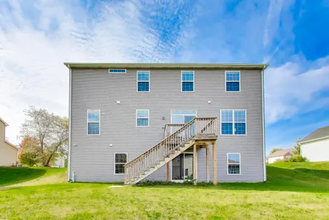 a view of a big house with a big yard and large trees