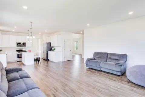 a living room with furniture and kitchen view