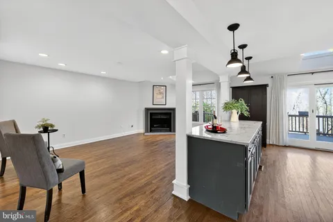 a living room with stainless steel appliances kitchen island granite countertop wooden floor a dining table and chairs