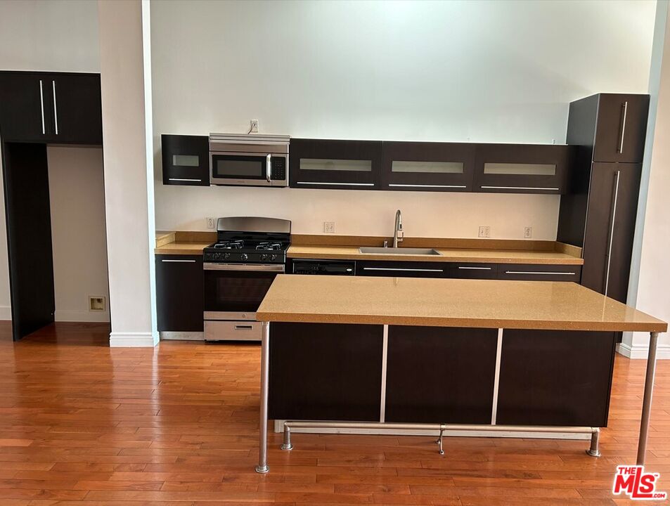 652 Mateo Street, Unit 303 Los Angeles, CA 90021 - Photo 1 of 12 a view of kitchen with stainless steel appliances wooden floor and cabinets