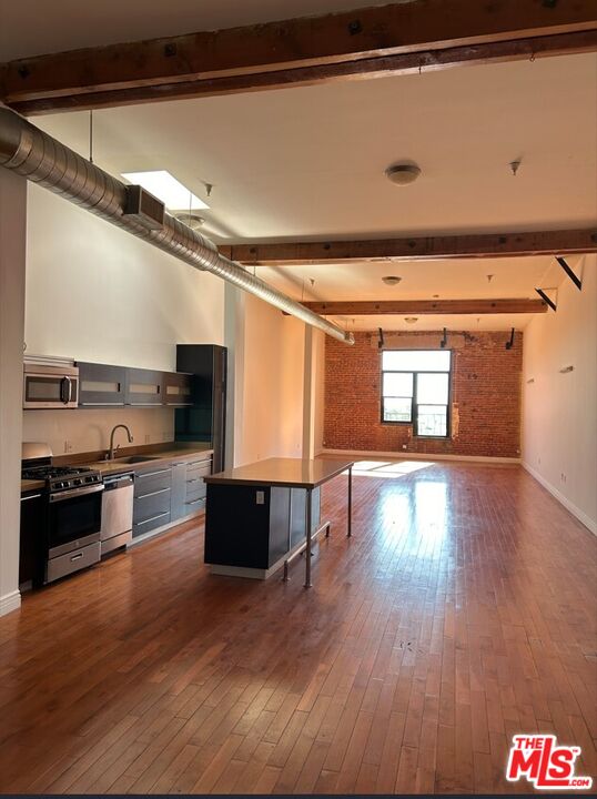 652 Mateo Street, Unit 303 Los Angeles, CA 90021 - Photo 2 of 12 a kitchen with stainless steel appliances granite countertop a stove and a refrigerator