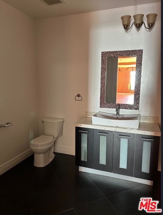 652 Mateo Street, Unit 303 Los Angeles, CA 90021 - Photo 7 of 12 a bathroom with a toilet sink and mirror