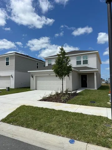a front view of a house with a yard and garage