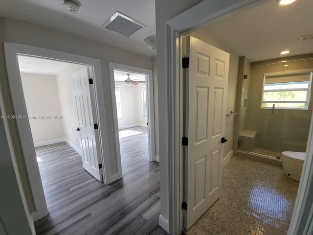 a view of a hallway with wooden floor and furniture