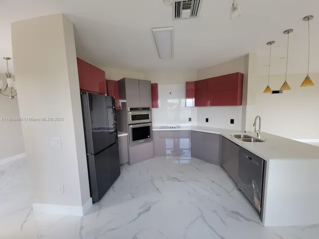 a large kitchen with cabinets and stainless steel appliances
