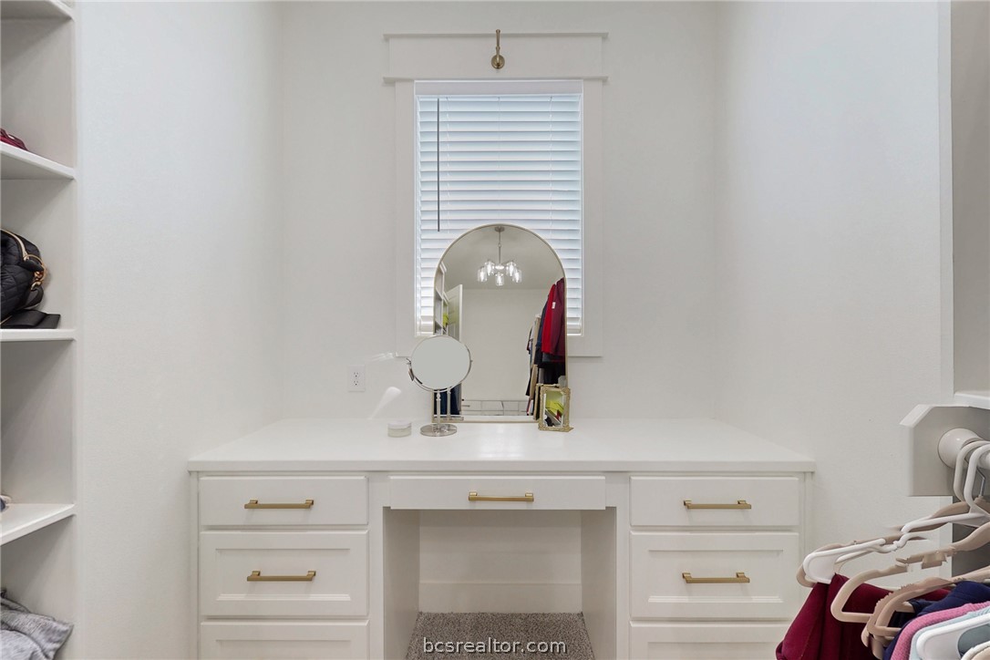 13504 Hudson Farms Road Hearne, TX 77859 - Photo 29 of 48 Primary walk in closet with a private built in vanity with lots of natural light, built in drawers at the other end and shoe racks.