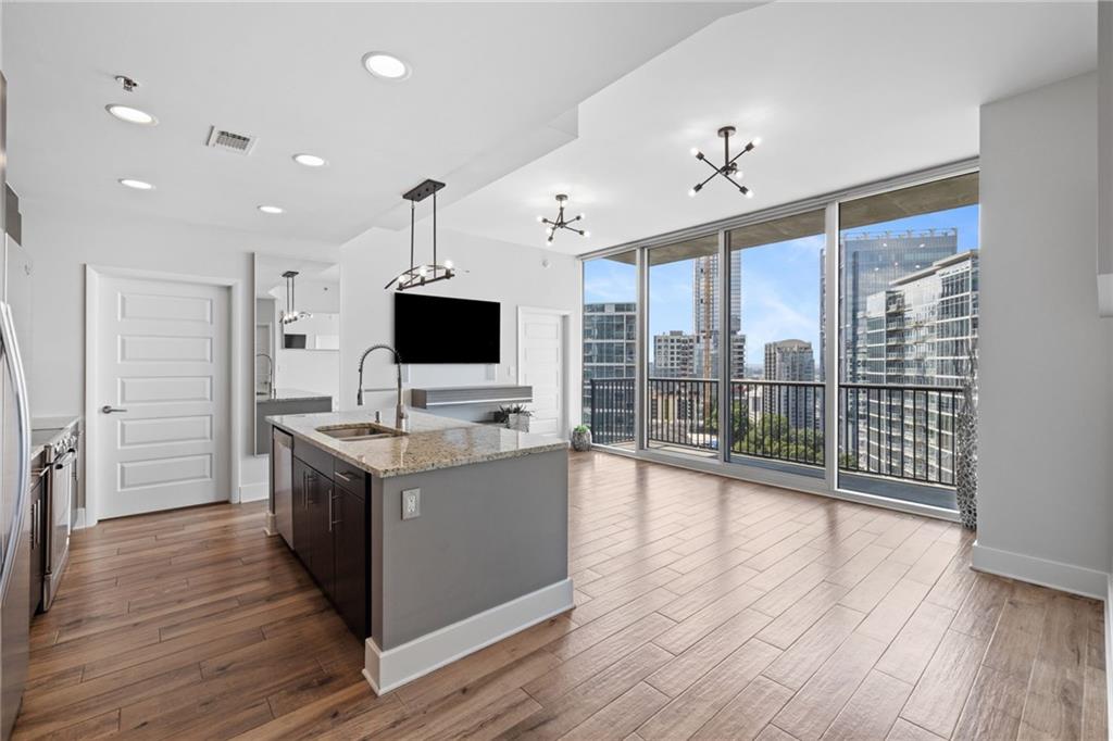 1080 Peachtree Street Northeast, Unit 1812 Atlanta, GA 30309 - Photo 1 of 13 a kitchen with a stove and a wooden floor