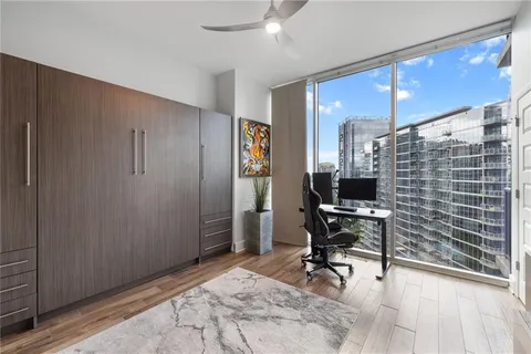 a view of a workspace with furniture and a window
