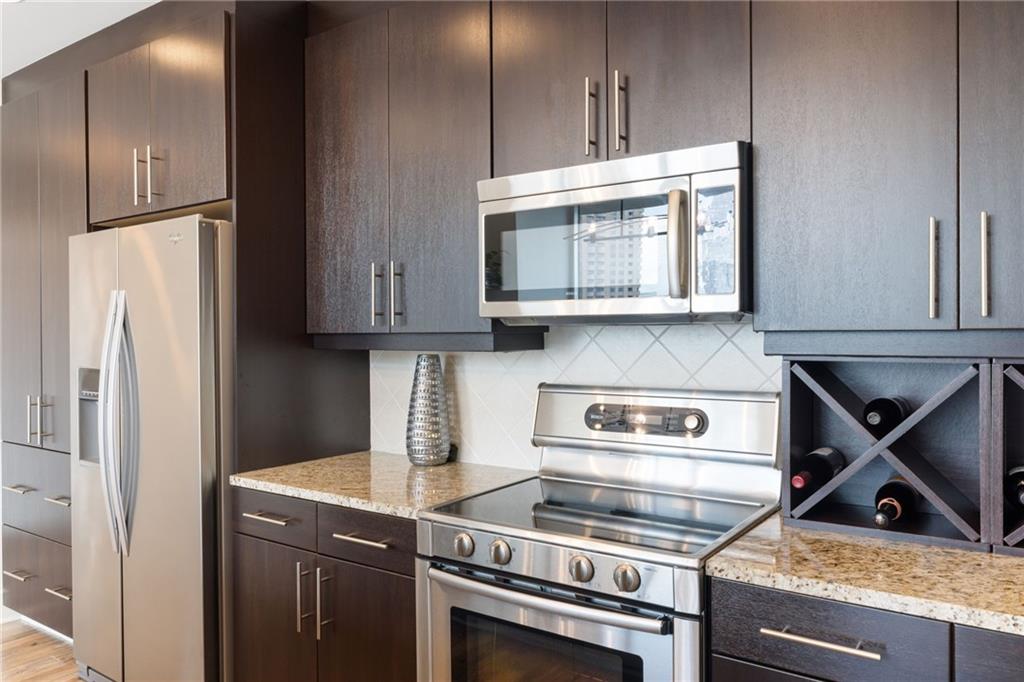 1080 Peachtree Street Northeast, Unit 1812 Atlanta, GA 30309 - Photo 7 of 13 a kitchen with stainless steel appliances granite countertop a refrigerator and a stove top oven