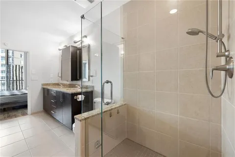 a bathroom with a granite countertop sink a toilet and shower