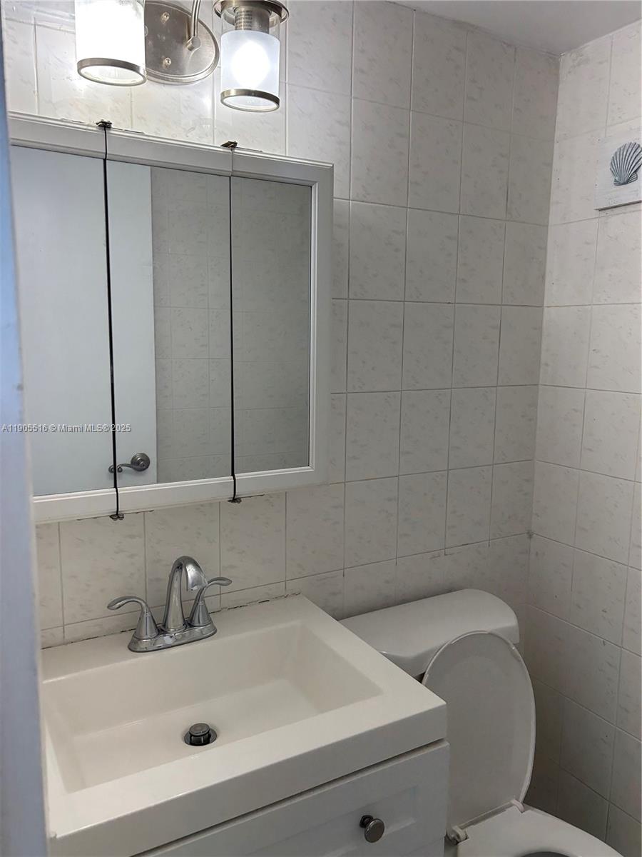 6969 Collins Avenue, Unit 607 Miami Beach, FL 33141 - Photo 13 of 15 a bathroom with a sink and a toilet