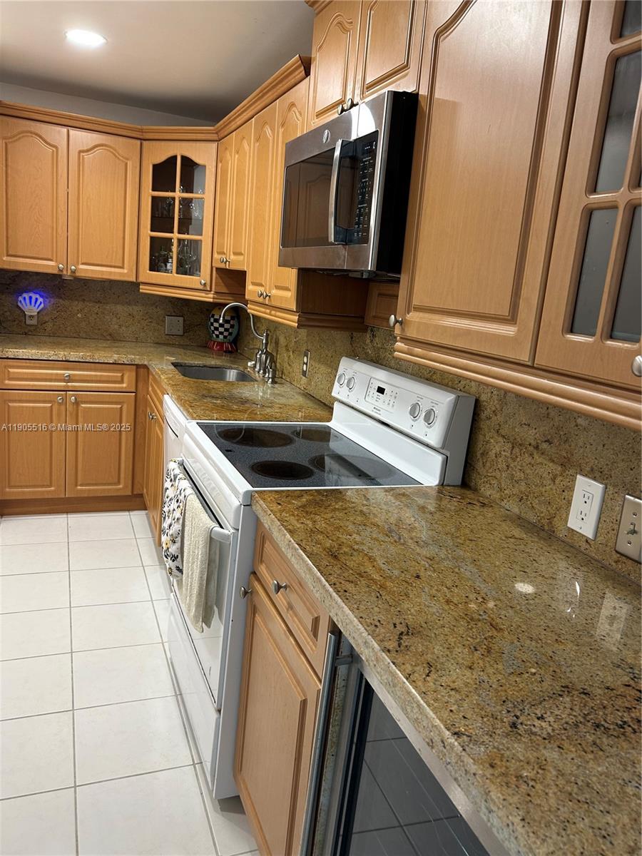 6969 Collins Avenue, Unit 607 Miami Beach, FL 33141 - Photo 9 of 15 a kitchen with stainless steel appliances granite countertop a sink stove and cabinets