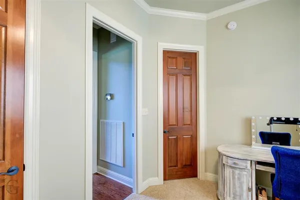 a view of a hallway with bathroom and wooden floor