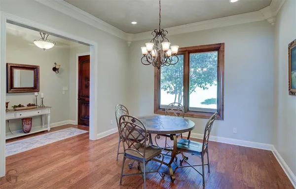 a view of a dining room with furniture a chandelier and wooden floor