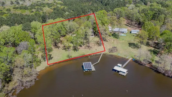 an aerial view of a house with a yard and lake view
