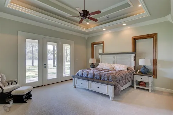 a spacious bedroom with a bed and a chandelier